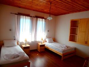 Arda米特尼瑟和TKZS碧丽安特斯酒店的一间卧室设有两张床、一个窗口和两盏灯。