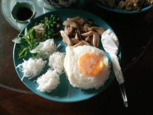 南奔ต้งโฮมหละปูน ณ ตูบคำ的蓝色的盘子,有鸡蛋和米饭