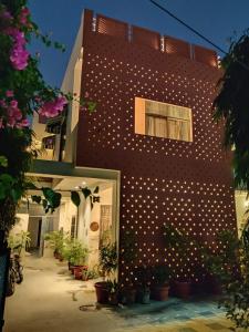 斋浦尔Kalpana Yoga Homestay的砖砌的建筑,上面有白色的波尔卡点