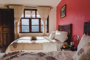 TlatlauquitepecHotel San Jorge的红色卧室设有两张床和窗户