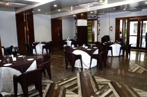 瓦拉纳西Hotel Abhinav International的餐厅配有桌椅和白色桌布
