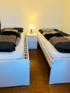 TassulloLa Casa di Olivo的两张睡床彼此相邻,位于一个房间里