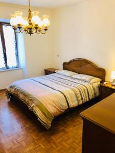 TassulloLa Casa di Olivo的一间卧室配有一张床和一个吊灯