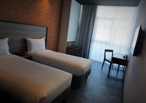 丹吉尔ONOMO Hotel Tanger Med的酒店客房,配有两张床和椅子