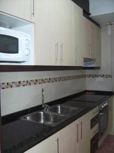 拉梅特拉·德·玛尔Apartamento funcional y acogedor的厨房配有水槽和微波炉
