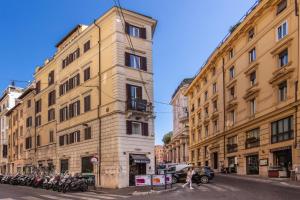 罗马Rome Art Hotel - Gruppo Trevi Hotels的一条城市街道上一座高大的建筑,上面有停放摩托车