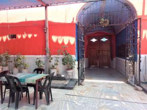 阿雷基帕Casona Moya的配有桌椅和红色墙壁的房间
