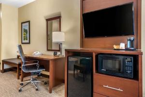 代顿Comfort Suites Dayton-Wright Patterson的酒店客房配有书桌和电视。