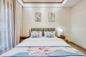 无锡拈花湾景区内花园庭院别墅套房---购票入住的卧室配有一张带蓝色和粉色枕头的大床