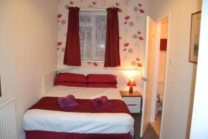 伦敦奇西克洛奇酒店的一间卧室配有一张带两顶紫色帽子的床