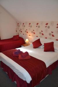 伦敦奇西克洛奇酒店的两张位于酒店客房的床,上面有红色枕头