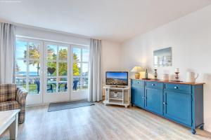 赛巴特班森Haus Rolandseck - FeWo 06的客厅配有蓝色橱柜和电视