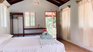 博卡斯德尔托罗Bird Island Bungalows的卧室配有白色的床和窗户。