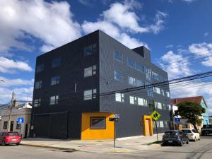 蓬塔阿雷纳斯Patagonia Apart Hotel - Suite的一条城市街道上的黑色和黄色建筑