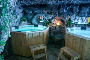 克卢日-纳波卡Gorgeous Villa的洞穴内的按摩浴缸,设有壁炉