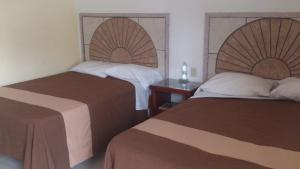 曼萨尼约Hotel Albatros Palace的酒店客房设有两张床和一张桌子。