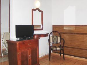 曼萨尼约奥巴特瑞酒店的配有电视、椅子和镜子的客房
