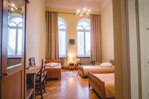 考纳斯Villa Kaunensis的酒店客房带两张床和一张桌子以及椅子。