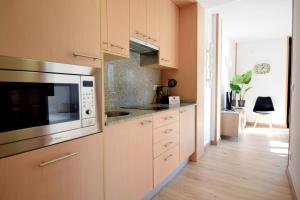 帕斯底拉卡萨Lux Renard "Acceso directo a pistas"的厨房配有白色橱柜和微波炉