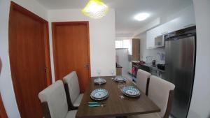 保罗阿方索城Condomínio Residencial Tranquilidade na Beira do Rio的厨房配有木桌、椅子和冰箱
