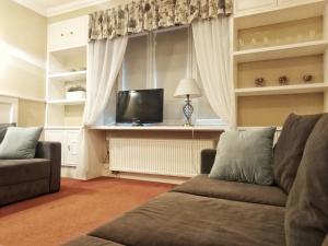 华沙赫纳拉美国豪斯酒店的带沙发和电视的客厅