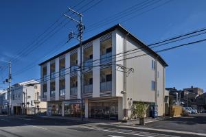 京都HOTEL ARROWS ARASHIYAMA的一条城市街道上的白色大建筑