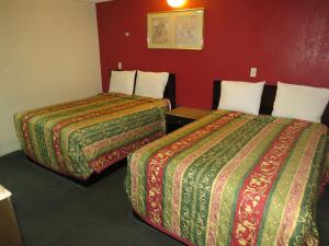 安纳海姆Calico Motel的酒店客房设有两张床和红色的墙壁。