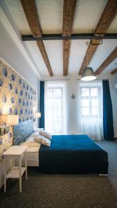 利沃夫Central Hotel的一间卧室配有一张蓝色的床和一张桌子