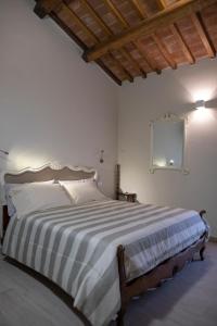 巴尼奥雷焦Il Palazzetto的一间卧室配有一张带条纹毯子的大床
