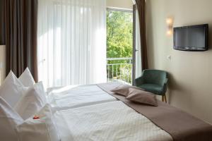 汉堡Stadthaushotel Hamburg - Inklusionshotel的卧室设有一张白色大床和一扇窗户。