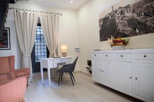 巴尼奥雷焦Il Palazzetto的白色的客房配有书桌和椅子