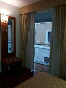 拉奎拉圣米歇尔酒店的一间卧室设有大窗户和镜子