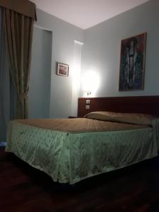 拉奎拉圣米歇尔酒店的一间卧室配有一张带绿床罩的床