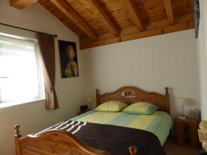 勒沙布勒莱斯金合欢住宿加早餐旅馆的一间卧室配有一张带木制床头板的床和窗户。