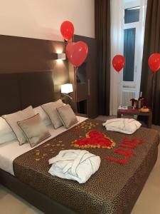 罗马Wellness Home Rome的一间卧室配有红色气球和一张带两个枕头的床
