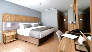 莱卡邦Canalis Suvarnabhumi Airport Hotel的一间卧室配有一张床和一张带电脑的书桌
