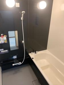 鹿儿岛ガナダン中央駅 1f 無料駐車場的带浴缸、水槽和镜子的浴室
