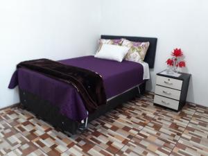 利马B&B La Casa del Turista的一间卧室配有紫色的床和床头柜