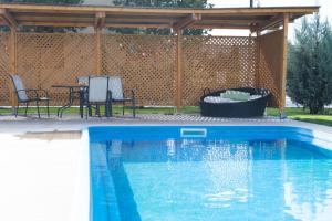 奥托佩尼Airport Residence - Apartment across from Otopeni Airport的一个带凉棚和桌椅的游泳池