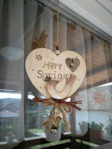PalkonyaMama vendégház - Palkonya的挂在窗户上的木心,上面写着快乐的春天