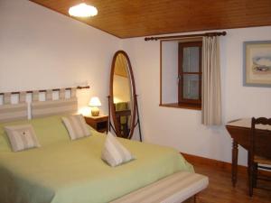 Saint-PorchaireChambres d'Hôtes Domaine Le Fragnaud的一间卧室配有绿色的床和镜子