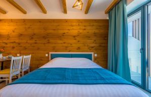 古多里NEW GUDAURI ATRIUM 336的一间卧室设有一张床和木墙