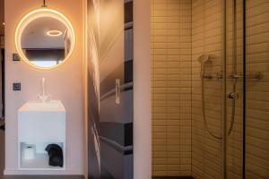 巴塞尔BLOOM Boutique Hotel & Lounge Basel的带淋浴、盥洗盆和镜子的浴室