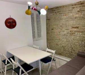 帕尔马[Storico] Ombelico di Parma的砖墙房间中的白色桌子和椅子