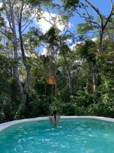 图卢姆Casa Tzalam Tulum selva的在一个有钟的游泳池里的人