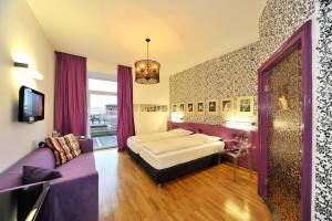 斯皮特安德劳尔尼博斯特艾艮特斯塔德酒店的一间卧室配有一张床和一张紫色沙发