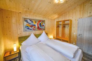 BundenthalFBA Village的卧室配有一张白色的木墙床