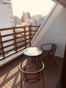 大阪WELLSTAY Honmachi的阳台配有一张桌子和两把椅子