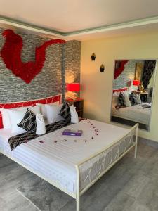 芭东海滩芳科与班南芬旅馆的一间卧室配有一张红色鲜花的大床