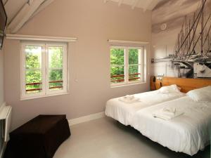 桑坦德桑坦德霍斯蒂亚酒店的一间卧室设有一张大床和两个窗户。